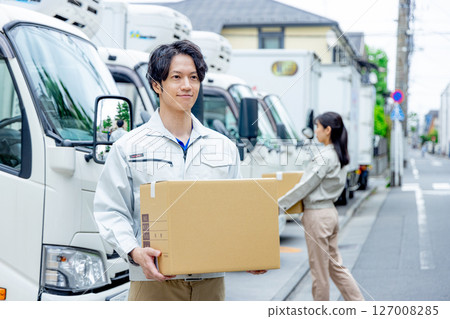 Male worker carrying cardboard Male worker carrying cardboard 127008285