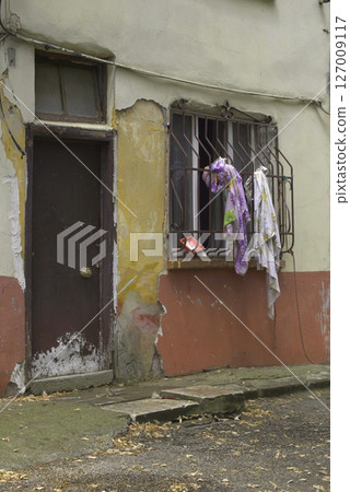 Old wooden door on a house wall. Conceptual image. Wooden Door on an Old House Wall. Architectural Details Worn and Weathered by Time.  127009117