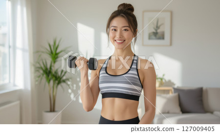 Healthy woman doing dumbbell exercises at home Healthy woman doing dumbbell exercises at home 127009405