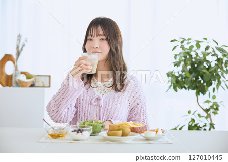 A woman eating breakfast on a refreshing early summer morning A woman eating breakfast on a refreshing early summer morning 127010445