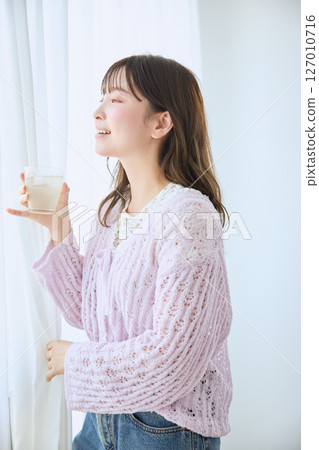 一位女士在窗邊喝著一杯果汁 127010716