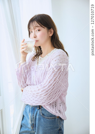 一位女士在窗邊喝著一杯果汁 127010719