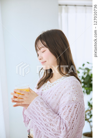 一位女士在窗邊喝著一杯果汁 127010736