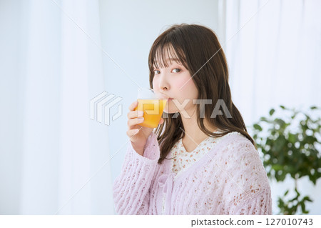一位女士在窗邊喝著一杯果汁 127010743
