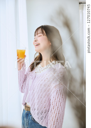 一位女士在窗邊喝著一杯果汁 127010745