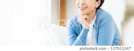 坐在客廳沙發上的中年婦女 127011247