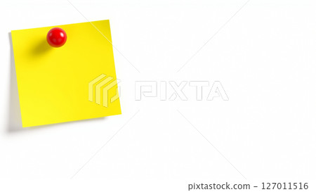 A yellow sheet of paper for notes is attached with a red pushpin to a white wall 127011516