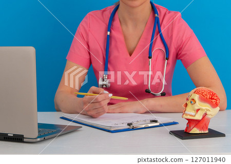 Anatomical model human head on work desk of doctor in medical clinic. 127011940