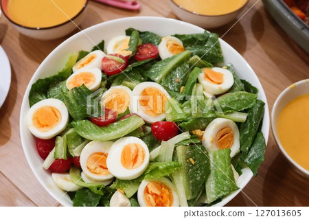 close up of homemade salad of boiled egg cut in slices, cherry tomato, lettuce in a big white bowl with pumpkin cream soup in the side close up of homemade salad of boiled egg cut in slices, cherry tomato, lettuce in a big white bowl with pumpkin cream soup in the side 127013605