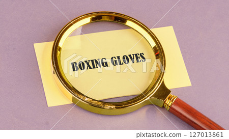 The words BOXING GLOVES Concept of health, sports through a magnifying glass on a yellow sticker, it symbolizes the importance of a healthy lifestyle The words BOXING GLOVES Concept of health, sports through a magnifying glass on a yellow sticker, it symbolizes the importance of a healthy lifestyle 127013861