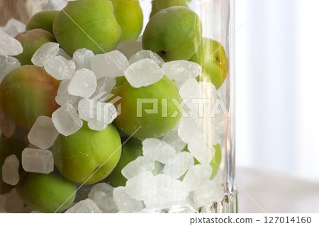 A storage jar filled with rock sugar and unripe plums 127014160