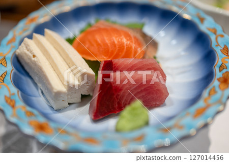 Fresh sashimi set with tuna, salmon, tofu and wasabi in a patterned ceramic dish Fresh sashimi set with tuna, salmon, tofu and wasabi in a patterned ceramic dish 127014456