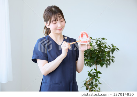 Dental hygienist giving brushing instructions 127014930