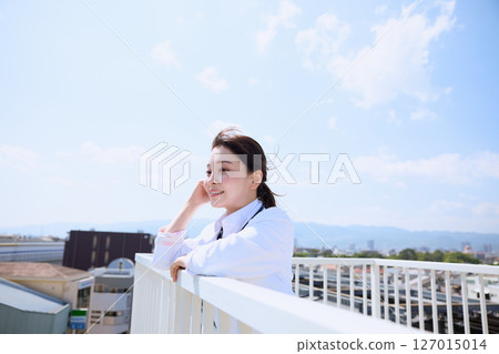 一位女醫生在醫院屋頂仰望天空 一位女醫生在醫院屋頂仰望天空 127015014