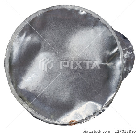 A crumpled, round, silver aluminum foil lid, viewed from above, isolated background 127015880
