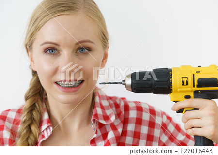 Woman with braces using drill on her teeth Woman with braces using drill on her teeth 127016443