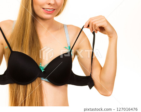 Woman trying on black pushup bra 127016476