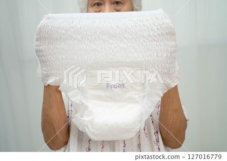 Asian senior woman patient wearing adult incontinence diaper pad in hospital. 127016779
