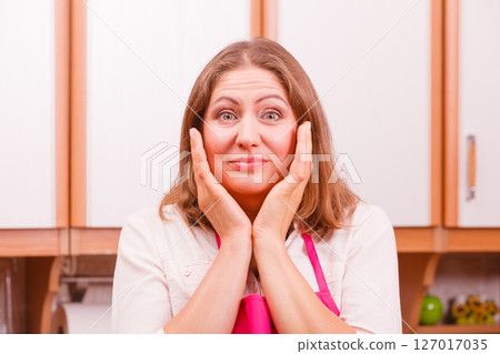 Unhappy housewife in kitchen 127017035