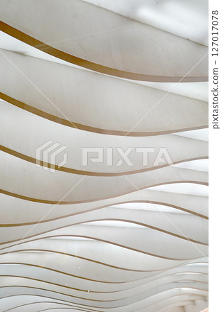 Wavy, layered panels create a dynamic, abstract pattern, playing with light and shadow. 127017078