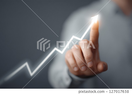 Businessman's hand with an upward arrow indicating growth Businessman's hand with an upward arrow indicating growth 127017638