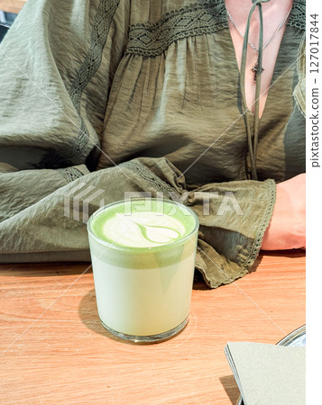 Green matcha latte close-up on wooden table. Drinks, modern lifestyle and coffee shop concept Green matcha latte close-up on wooden table. Drinks, modern lifestyle and coffee shop concept 127017844