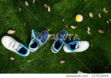 Children's Sneakers on Grass with Tennis Ball Children's Sneakers on Grass with Tennis Ball 127018049