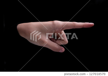 Female hand of caucasian woman pointing fingers to the right side on black background Female hand of caucasian woman pointing fingers to the right side on black background 127018570