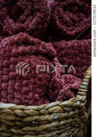 Straw basket full of warm plaids 127019032