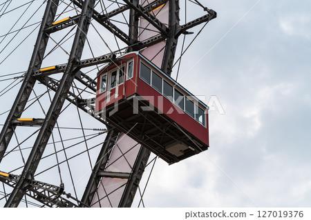 Vintage red cabin on a Ferris wheel, taken close-up with visible metal framework Vintage red cabin on a Ferris wheel, taken close-up with visible metal framework 127019376
