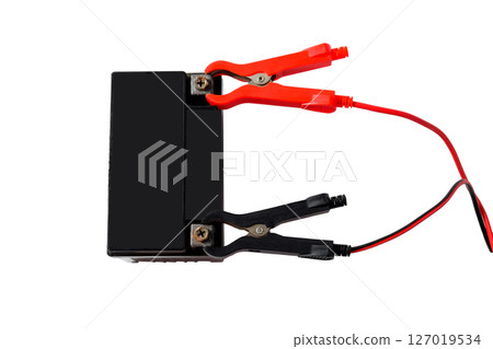 A motorcycle battery, charging with red and black cables. 127019534