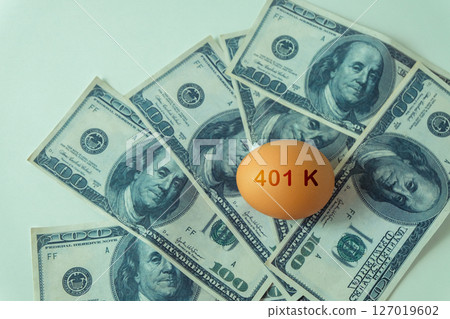 401k  Plan note on egg and Pile of US Money. 127019602