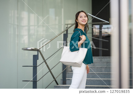 Young woman walking in front of a building 127019835