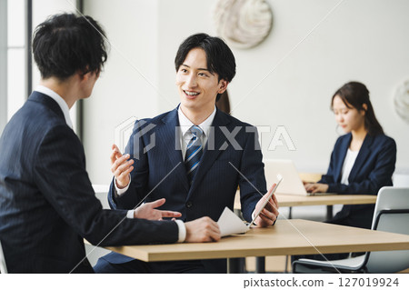 Refreshing young businessmen having a meeting at a table in a free space Refreshing young businessmen having a meeting at a table in a free space 127019924