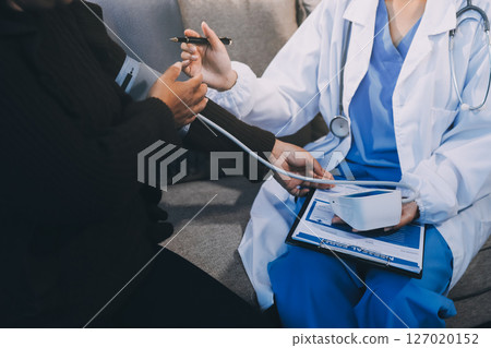 Doctor using Blood pressure monitor and stethoscope checking measuring arterial blood pressure on arm to a patient in the hospital, healthcare and medical concept 127020152