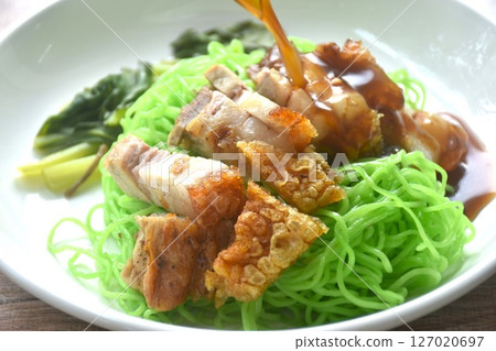 Chinese jade noodles topping roasted crispy pork dipping sweet soy sauce on plate  127020697