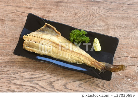 grilled salty shima hokke fish or Akta mackerel with lemon and parsley on plate grilled salty shima hokke fish or Akta mackerel with lemon and parsley on plate 127020699