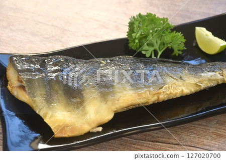 grilled salty shima hokke fish or Akta mackerel with lemon and parsley on plate grilled salty shima hokke fish or Akta mackerel with lemon and parsley on plate 127020700