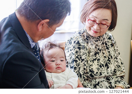 Grandparents holding their first grandchild Grandparents holding their first grandchild 127021444