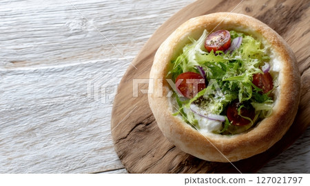 Refreshingly vibrant salad served in a baked dough bowl, embodying eco-friendly dining principles 127021797