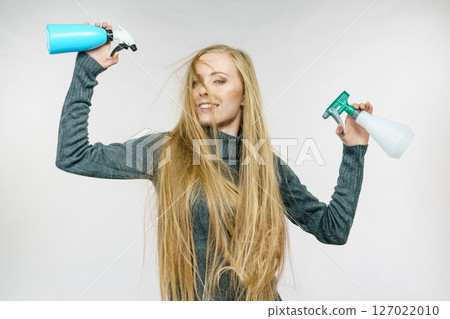 Female messy long hair holds spray bottle 127022010