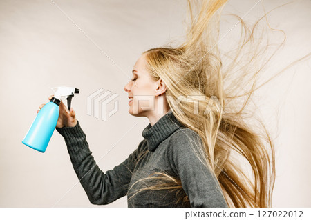 Girl apply spray water treatment on face 127022012