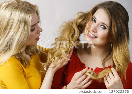Two girls creating hairdo. Hair ombre color 127022276
