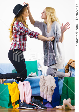 Two happy female friends after shopping 127022313