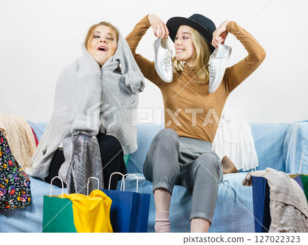 Two happy female friends after shopping 127022323