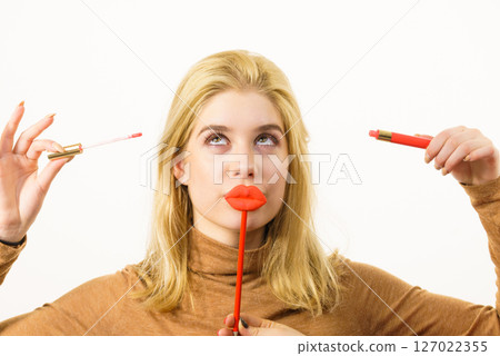 Woman applying lipstick or lip gloss Woman applying lipstick or lip gloss 127022355