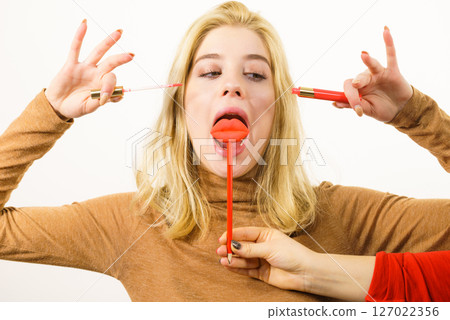 Woman applying lipstick or lip gloss Woman applying lipstick or lip gloss 127022356