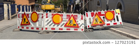 Banner Street closed for construction work. Traffic barriers with warning signs and excavator visible in residential area. 127023191
