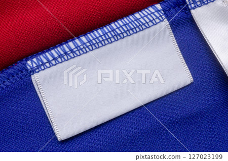 White blank laundry care clothes label on blue shirt fabric background 127023199