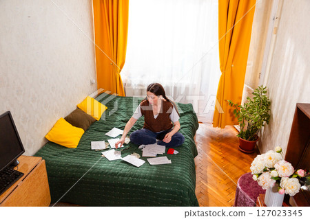 Woman organizing financial records and managing expenses for a stable financial future. concept of economy and financial security. Wide shot, wide shot 127023345